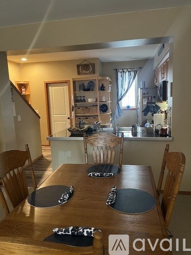 A dining room with a wooden table and chairs.