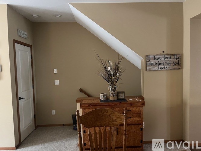 A room with a wooden dresser and a sign on the wall.