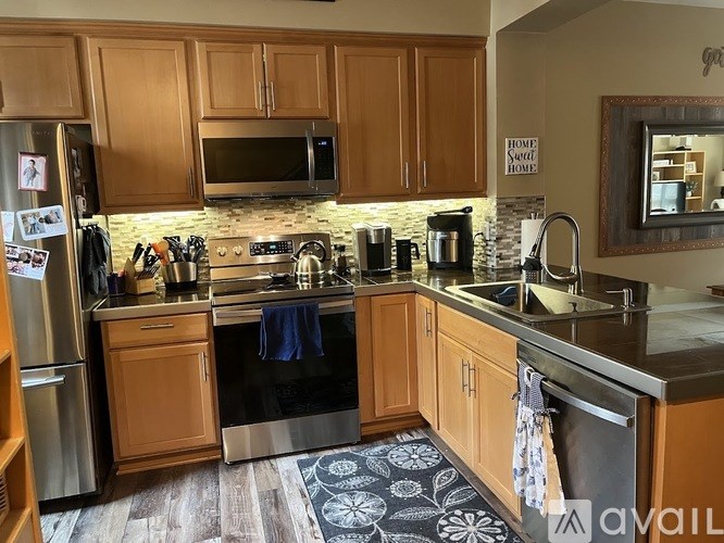 A kitchen with wooden cabinets and a stainless steel refrigerator.