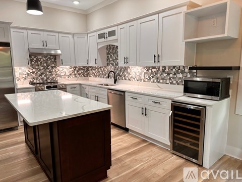 A kitchen with white cabinets and a dark counter top.