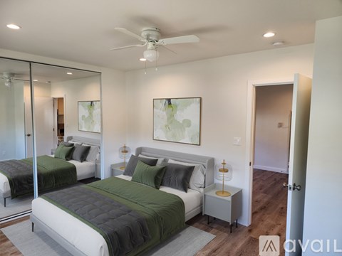 A bedroom with two beds and a ceiling fan.