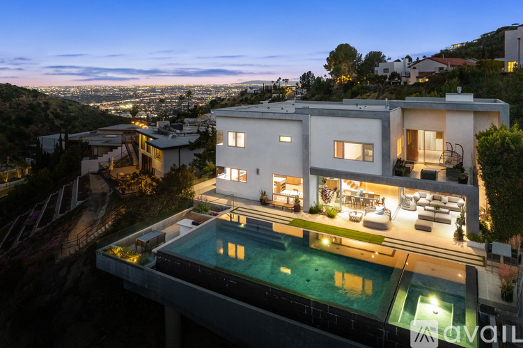 A modern house with a pool at night.