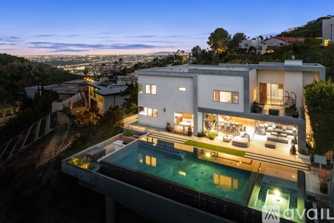 A modern house with a pool at night.
