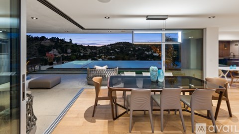 A modern dining room with a glass table and chairs.