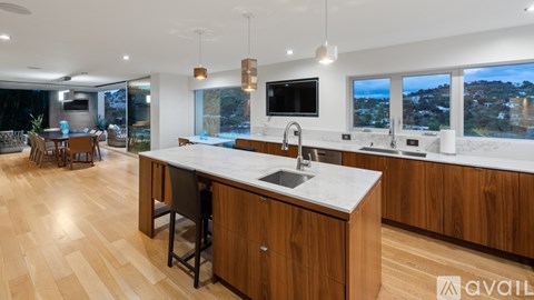 A modern kitchen with wooden cabinets and a marble countertop.