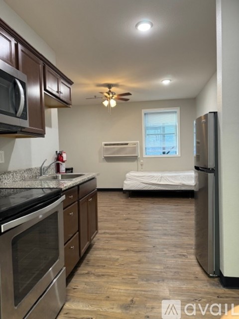 A kitchen with wooden cabinets and a stainless steel refrigerator.