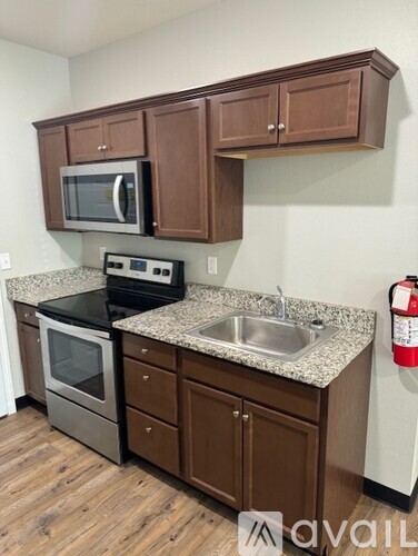 A kitchen with brown cabinets and a granite countertop.