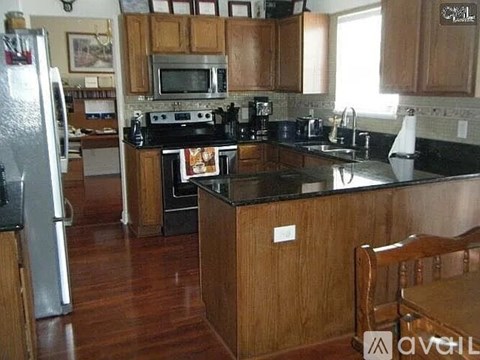 A kitchen with wooden cabinets and a black countertop.