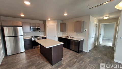 A kitchen with a refrigerator, oven, and sink.