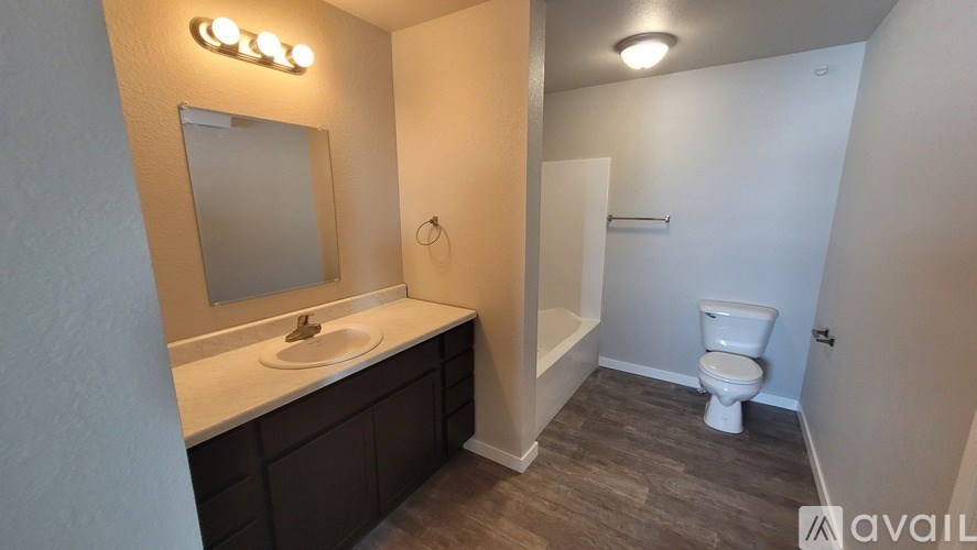 A bathroom with a toilet, sink, and mirror.