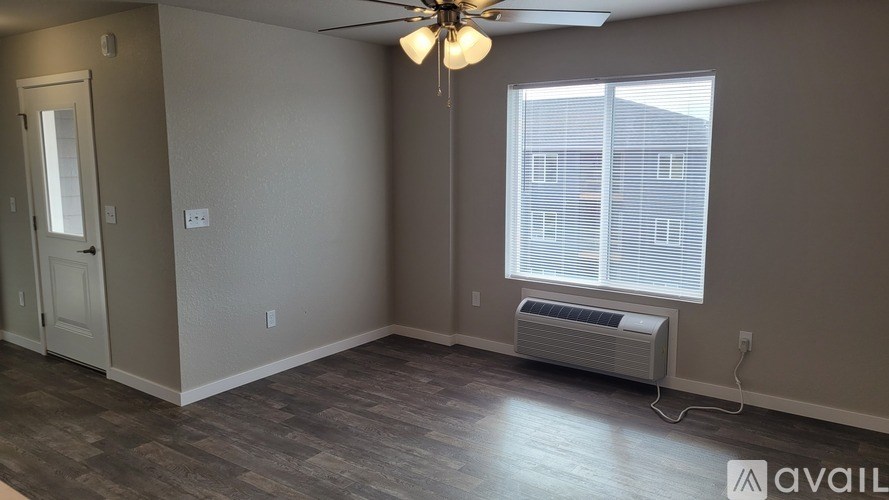 A room with a ceiling fan and a window with blinds.