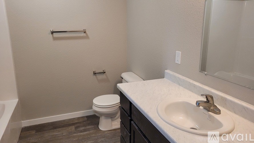 A bathroom with a toilet, sink, and a mirror.
