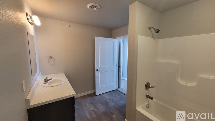 A bathroom with a sink, mirror, and bathtub.