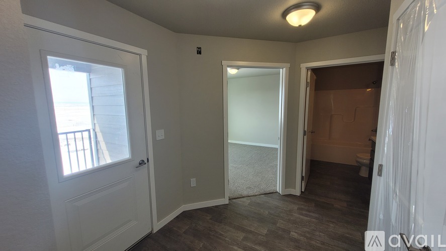 A room with a window, a door, and a carpeted floor.