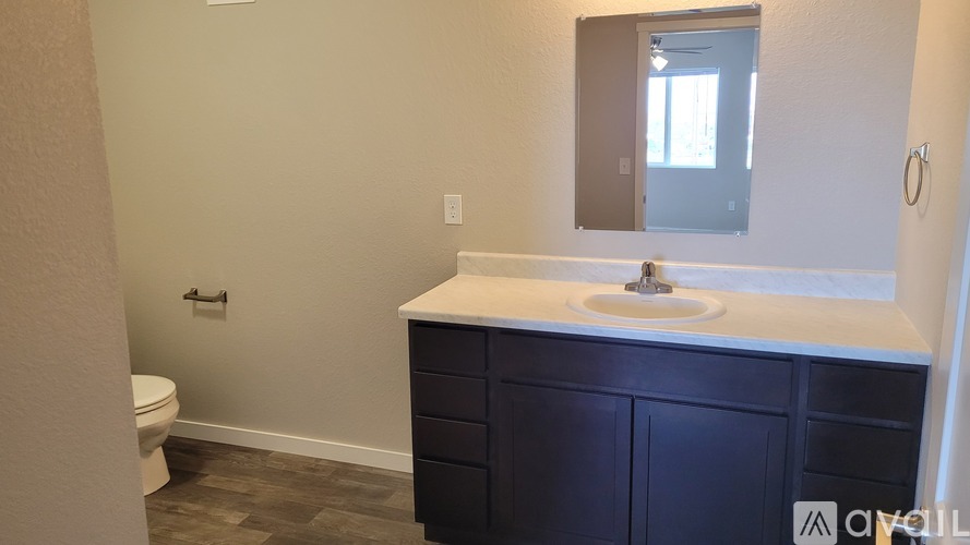 A bathroom with a white countertop and a white sink.