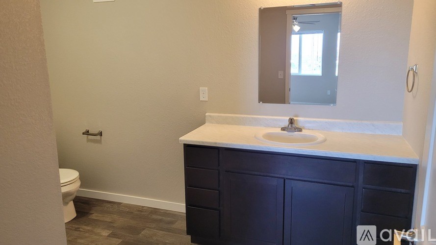 A bathroom with a white countertop and a white sink.