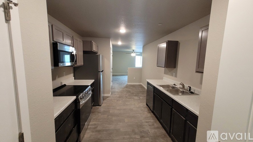 A kitchen with black cabinets and appliances is available for rent.