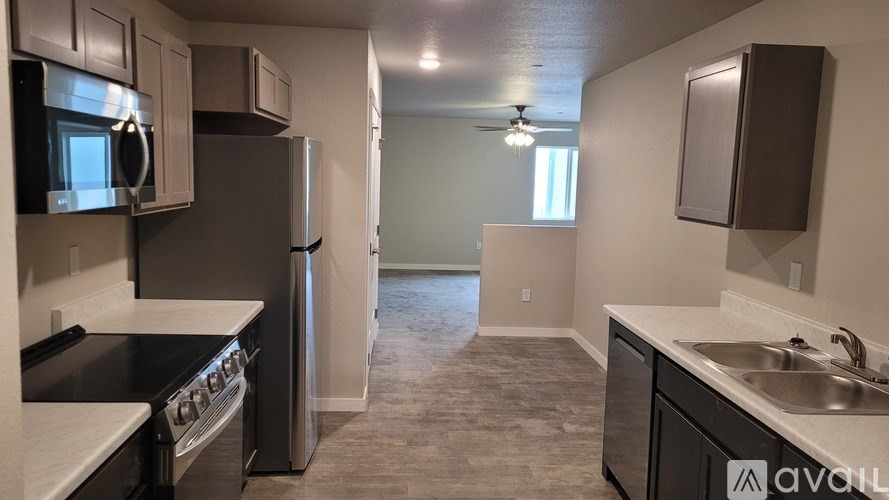A kitchen with a black countertop and stainless steel appliances.