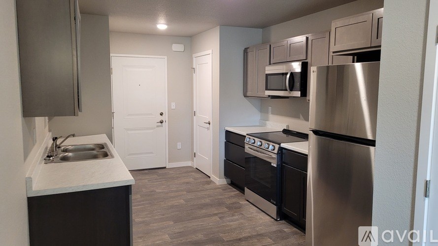A kitchen with a stainless steel refrigerator, oven, and microwave.