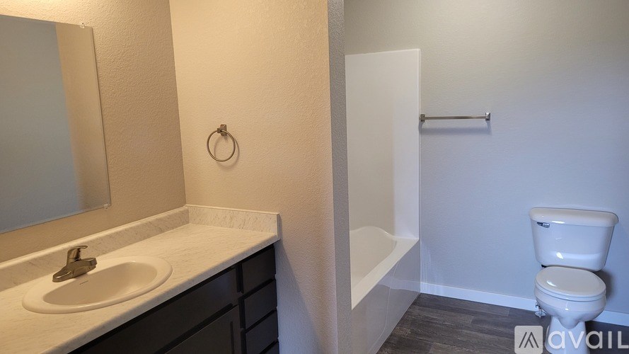 A bathroom with a toilet, sink, and mirror.