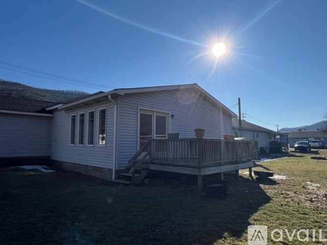 A house with a porch and a cat sitting on it.