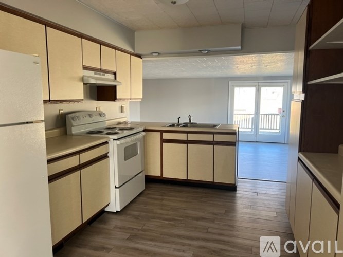 A kitchen with white appliances and wooden cabinets.