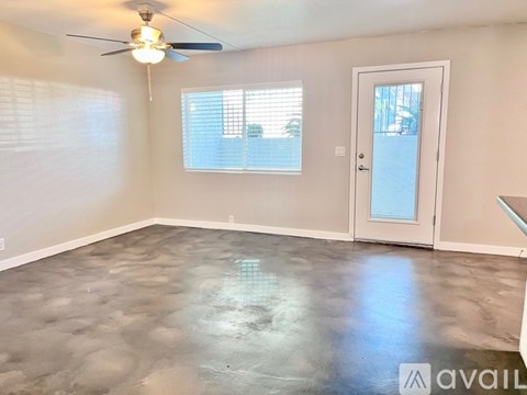 A room with a ceiling fan and a door leading to a balcony.