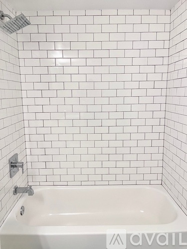 A white bathtub with a shower head above it.