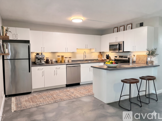 A kitchen with white cabinets and a stainless steel dishwasher.