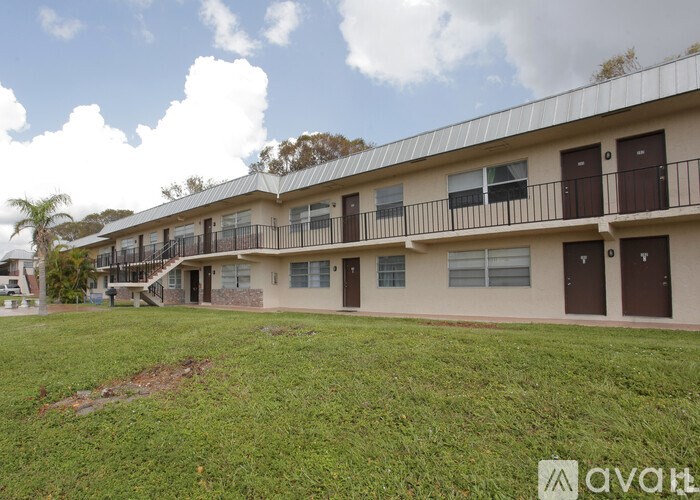 A row of houses with balconies and a grassy area in front.