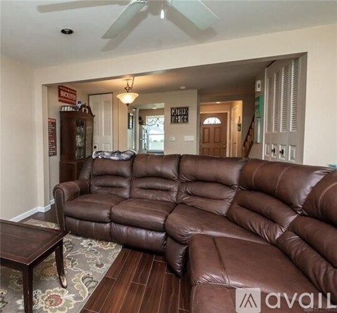 A brown leather sectional sofa in a living room.