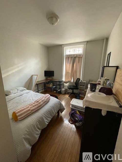 A bedroom with a bed, desk, and chair.