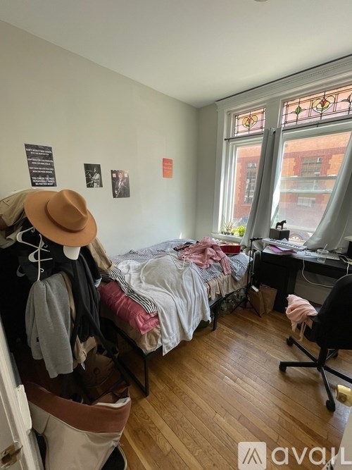 A room with a bed, desk, and chair.