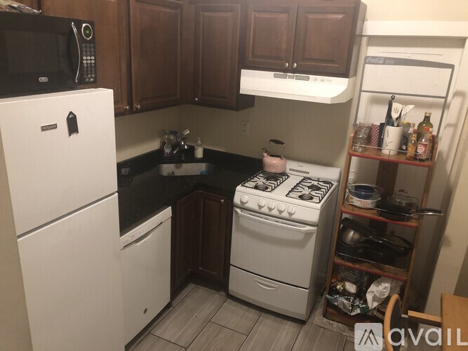 A kitchen with a white fridge, white stove, and wooden cabinets.