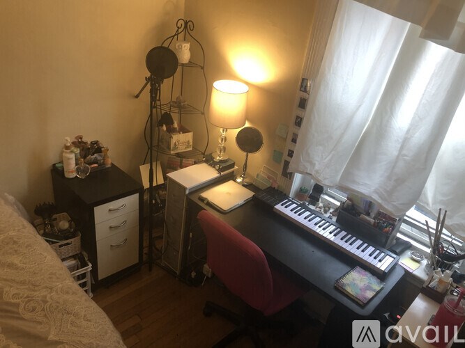 A room with a desk, chair, and a lamp.