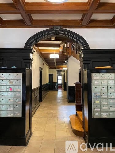 A hallway with a vaulted ceiling and a row of mailboxes on the left side.