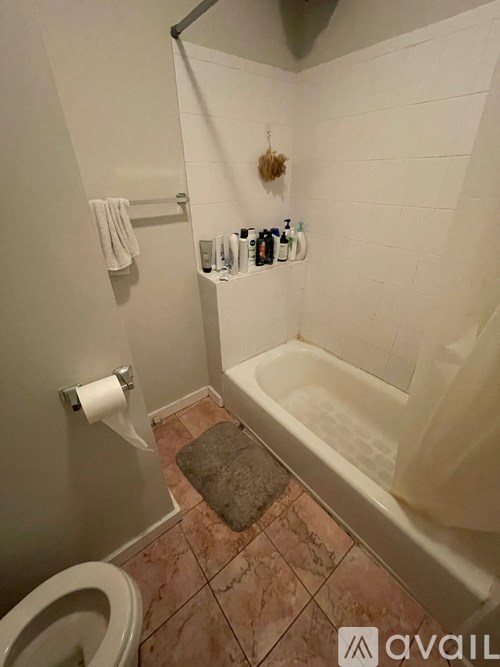 A bathroom with a toilet, a towel rack, and a bathtub.