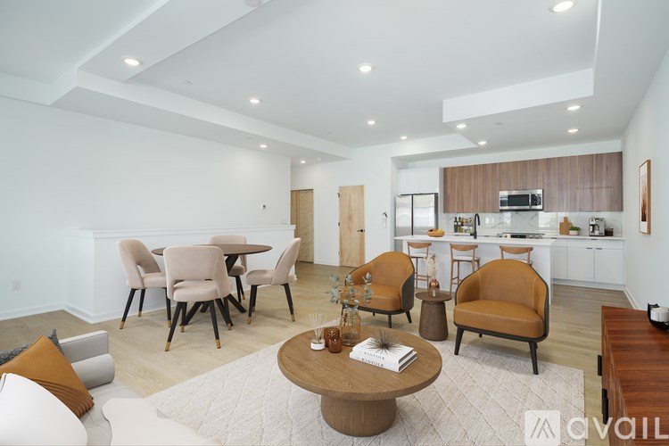 A modern living room with a dining area and kitchen in the background.