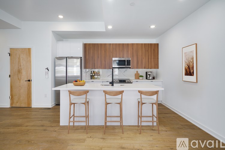 A kitchen with white countertops and wooden cabinets.