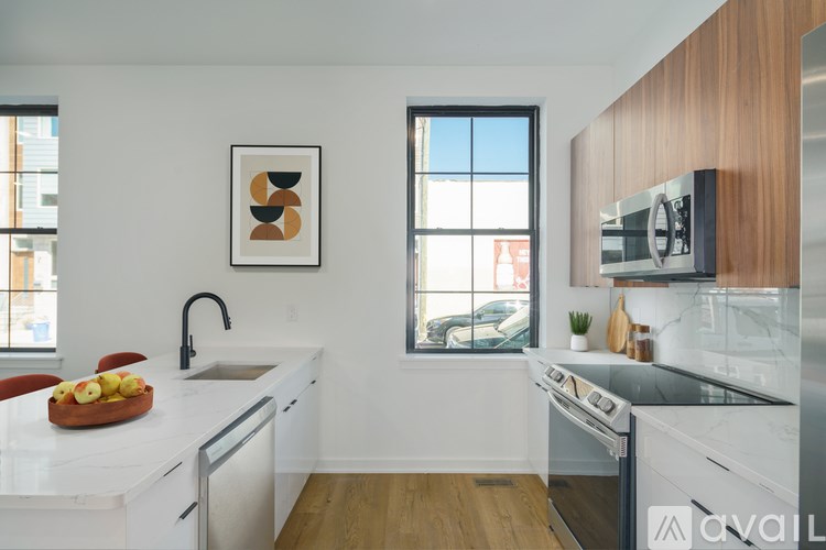 A modern kitchen with a white countertop and a wooden cabinet.