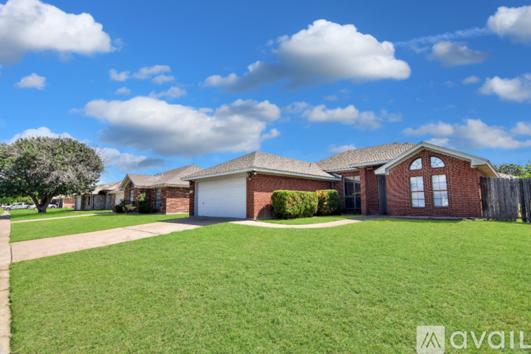 A house with a red brick exterior and a large front yard.