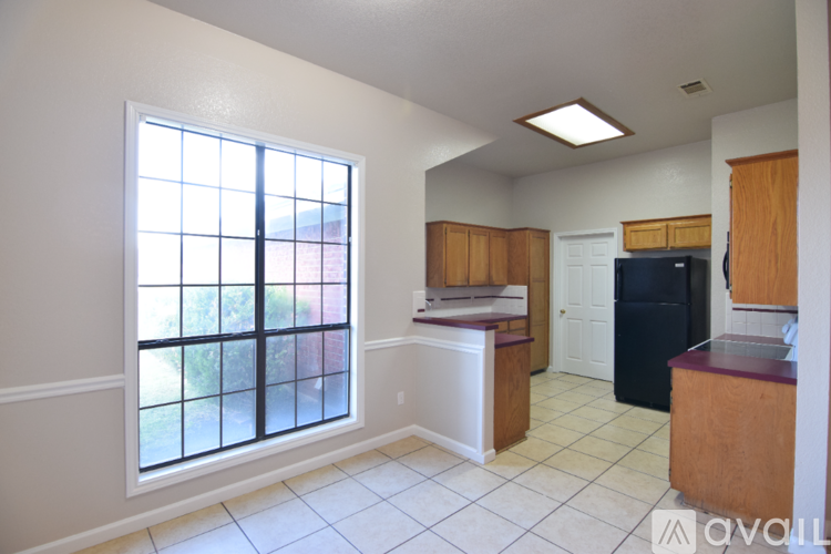 A kitchen with a black refrigerator, a microwave, and a stove top oven.