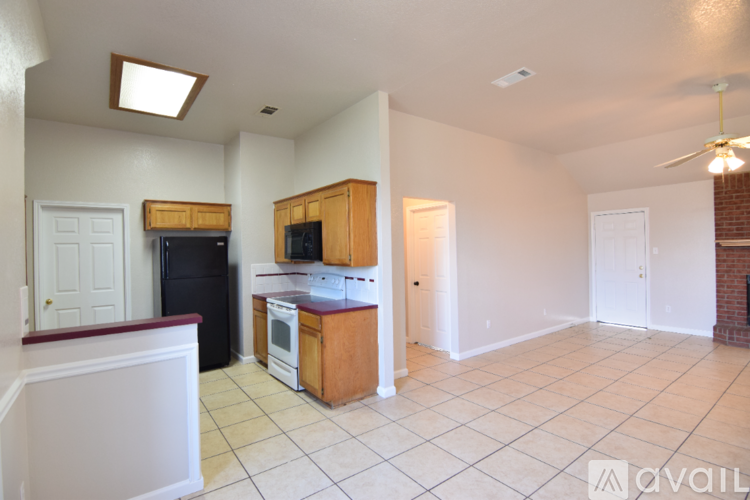A kitchen with wooden cabinets and a black refrigerator.