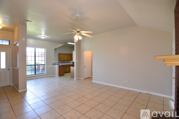 A spacious room with a ceiling fan and tiled flooring.