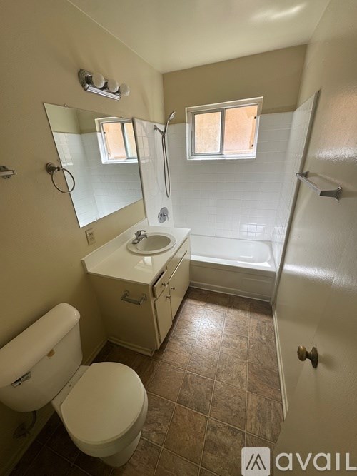 A bathroom with a toilet, sink, and bathtub.