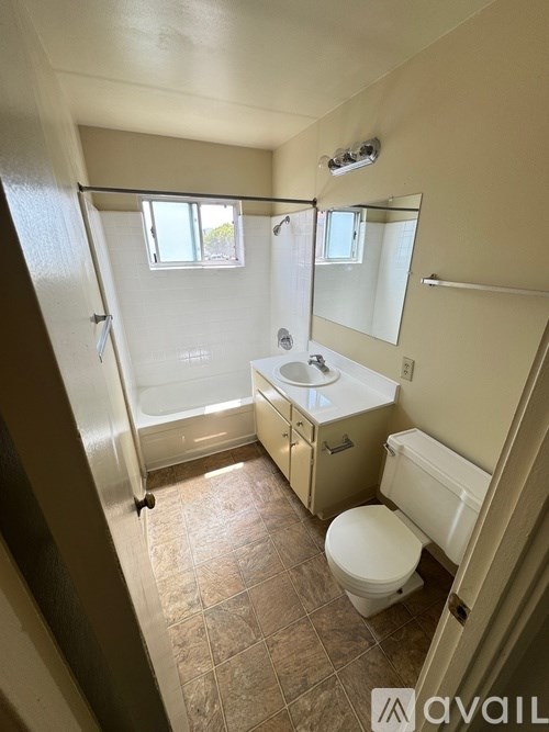 A bathroom with a toilet, sink, and shower.