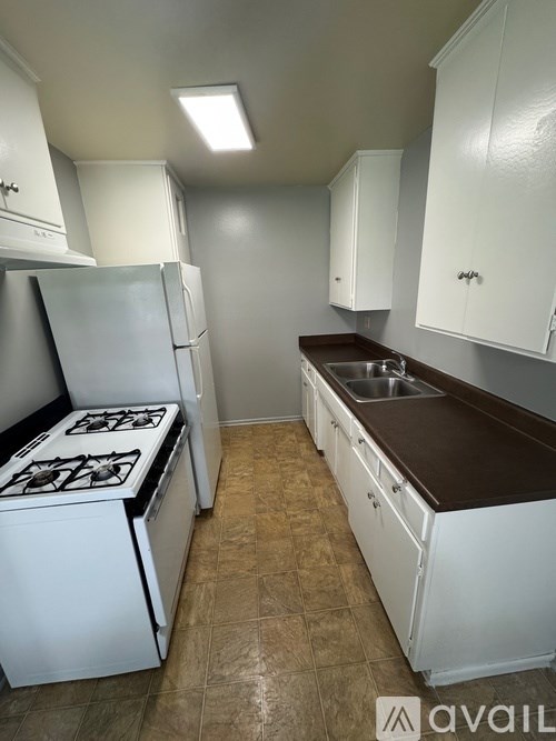 A kitchen with white appliances and cabinets.