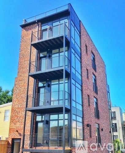 A tall building with a red brick facade and black balconies.