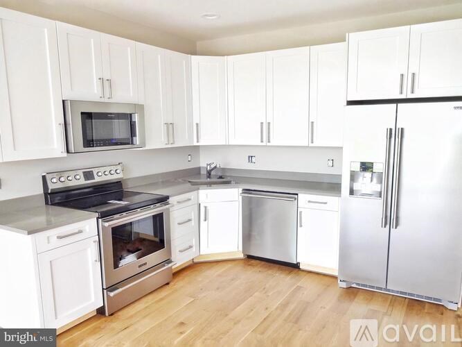 A kitchen with white cabinets and stainless steel appliances.