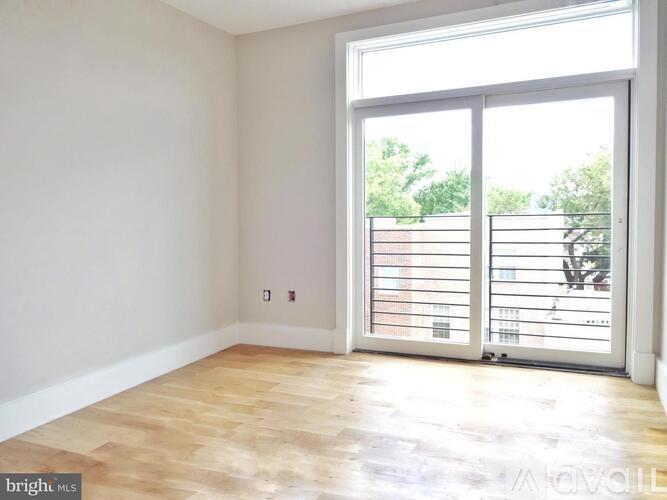 A room with a sliding glass door leading to a balcony.